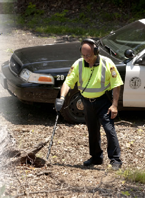 Foto policial procurando com o Detector de Metais Garrett CSI Pro objetos de cena do crime
