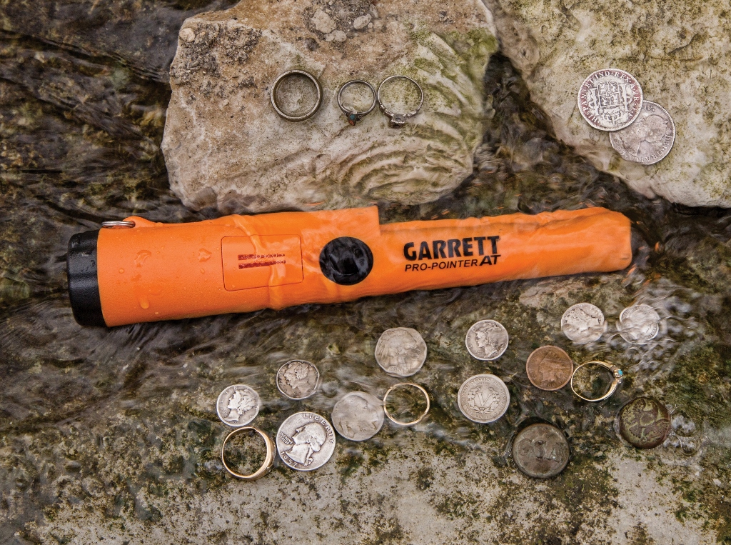 Foto do Detector de Metal Portátil Garrett PRO-POINTER AT Z-LINK dentro da água com várias moedas e joias